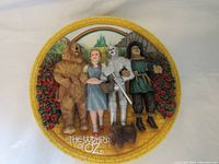 Photo shows a decorative plate portraying Dorothy and main characters from The Wizard of Oz.