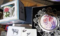 Pewter picture frame, floral mug in box, and other boxed items arranged on floor