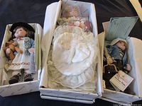 Photo showing all three boxed collector dolls with visible tags and certificates.