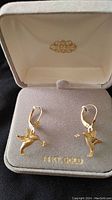 Pair of 14K gold hummingbird earrings holding flowers displayed in a beige velvet jewelry box marked 14 KT. GOLD