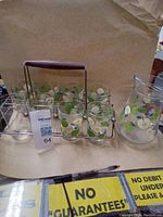 Full set shown including eight glasses, one pitcher, and metal wire rack with wooden handle.