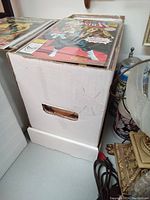 Photo of white cardboard comic box filled with comics, box not included in lot