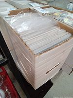 Full view of cardboard storage box mostly filled with individually bagged comics, showing care in item preservation.