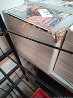 View of a box filled with comics showing colorful covers and protective sleeves.