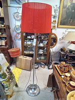 Full view of red shade standing metal floor lamp in vintage setting