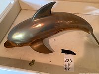 Overhead view of polished brass dolphin figurine