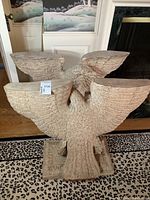 Front view of both carved eagle bases showing wing supports and plinth bases