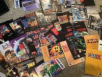 Top-down view of assorted video game promotional inserts and magazines spread on floor