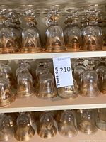 Upside-down clear glass goblets with gold-tone banding on upper and middle shelf