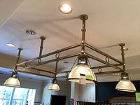 Rectangular brass frame supporting four ribbed glass dome shades suspended by six rods