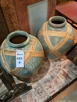 Two vases shown side by side on brick surface near fireplace; full view of lot.