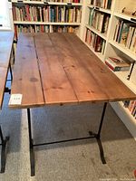 Front view of table showing wooden plank top and metal base