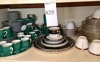 overview of green Neiman Marcus malachite dishes on left and Spode black, white and gold dishes center and right