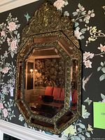 Front view of entire ornate octagonal mirror mounted on wall