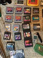 Loose handheld LCD game cartridges and portable consoles laid out