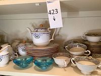 Full view of Royal Doulton patterned teapot, sugar bowl, creamer, cups and plates