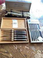 Three sets of cutting and steak knives plus cocktail utensils kit displayed on table
