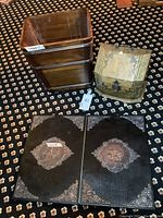 Overall view of folio covers laid flat beside wooden wastebasket and filing box