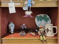 Shelf view showing porcelain vase, Steuben duck, Lalique horse, trinket dish and decanter with other décor