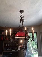 Full view of chandelier hanging in dining nook with lights on