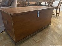 Side view of the pine toy box showing the solid wood construction and casters.