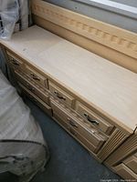 Top view of large dresser showing the carved decorative edge and multiple drawers with metal handles.
