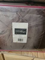 Close-up of Avenue Eight comforter in clear packaging, label visible with brand and queen size designation.