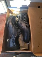 Black leather Bass shoes side view in box showing shoe profile and leather texture.