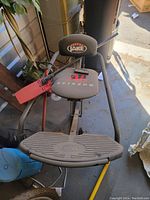 Front angled view of Body By Jake Ab Scissor exercise equipment showing seat, foot platform, and part of the frame