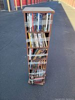 Full view of the wooden DVD storage case with DVDs wrapped in tape for stability.