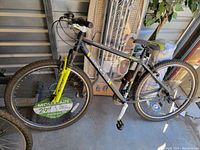 Side view of Genesis mountain bike, showing frame design, pedals, saddle, and front suspension fork colored bright yellow.