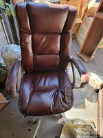 Front view of brown faux leather office chair showing padded backrest and armrests with wear