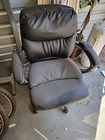 Full front view of the black office chair showing padded seat, backrest, and armrests.