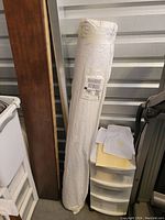 Rolled rug in original plastic packaging leaning inside a unit