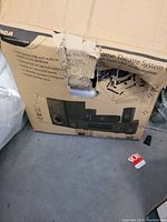 Damaged cardboard box showing the RCA home theatre system and speaker placement graphics.