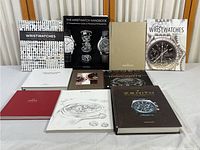 Full view of the watch books arranged on a table, showing 11 volumes including the Wristwatches handbook and Zenith book.