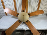 Overhead view of the five wooden blades and the dome-shaped light fixture.