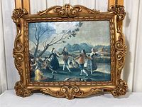Full image of the framed print showing dancing figures by a riverbank with blue sky and landscape background.