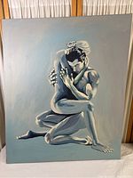 Full view of the painting showing two nude lovers embracing, highlighted in shades of blue and gray, with the frame visible and warped.