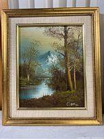 Framed signed painting showing mountain, stream, and trees composition, overall view
