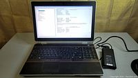 Dell Latitude E6520 laptop powered on, showing keyboard and display