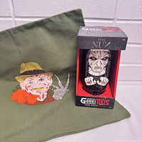 Photo showing the Freddy Krueger pillowcase alongside The Nun Geeki Tikis mug in original box.