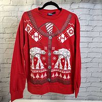 Front view of red long sleeve Star Wars ugly Christmas t-shirt with printed graphic mimicking a cardigan with Star Wars theme including AT-AT walkers and TIE fighters.