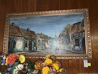 Front view of framed painting showing street scene with row of buildings