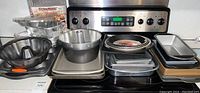 Wide shot showing the full variety of baking pans including Bundt, loaf pans, cookie sheets, and foil pans.