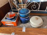 Overall view of two stoneware loaf pans, two blue cast iron pieces, and one white Dutch oven