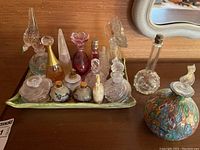 Full tray of assorted perfume bottles on green dish
