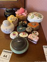 Overview of all 13 trinket boxes of various materials and styles on wooden surface