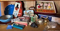 Overview of the various vintage barware items including ashtrays, matchboxes, door signs, and novelty items.