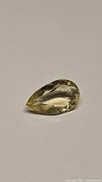 Photo of the natural lemon citrine gemstone in pear cut showing its color, clarity, and facets.